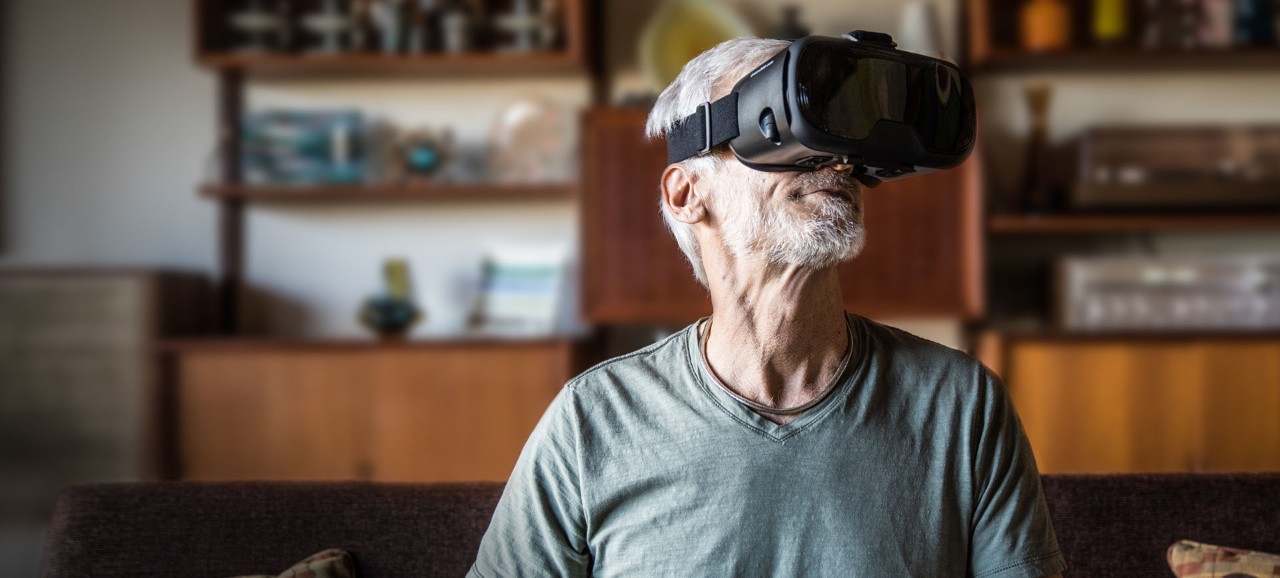 An older man wearing a virtual reality headset looking up